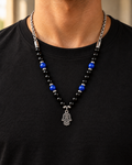 Black and blue beaded hamsa necklace worn over a black t-shirt