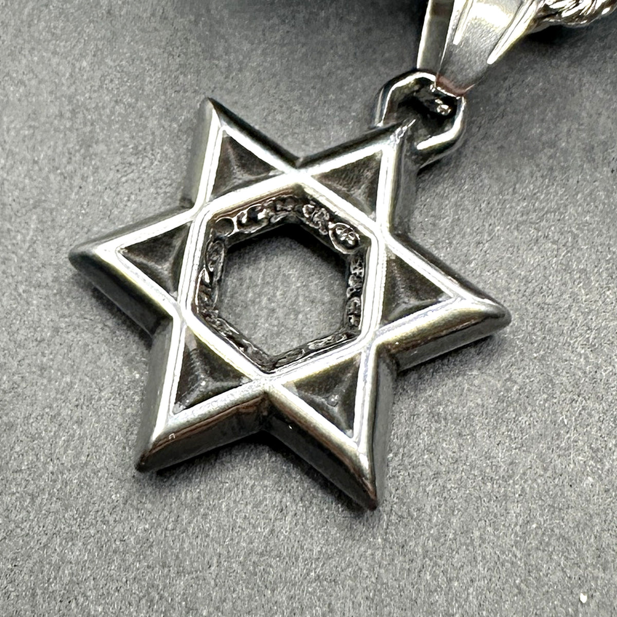 Close-up of the blackened Star of David showing polished edges and dark faces