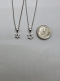 Both Star of David pendant sizes beside a dime, 6mm and 7.5mm across