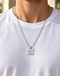 Silver dove hamsa pendant necklace worn over a white t-shirt