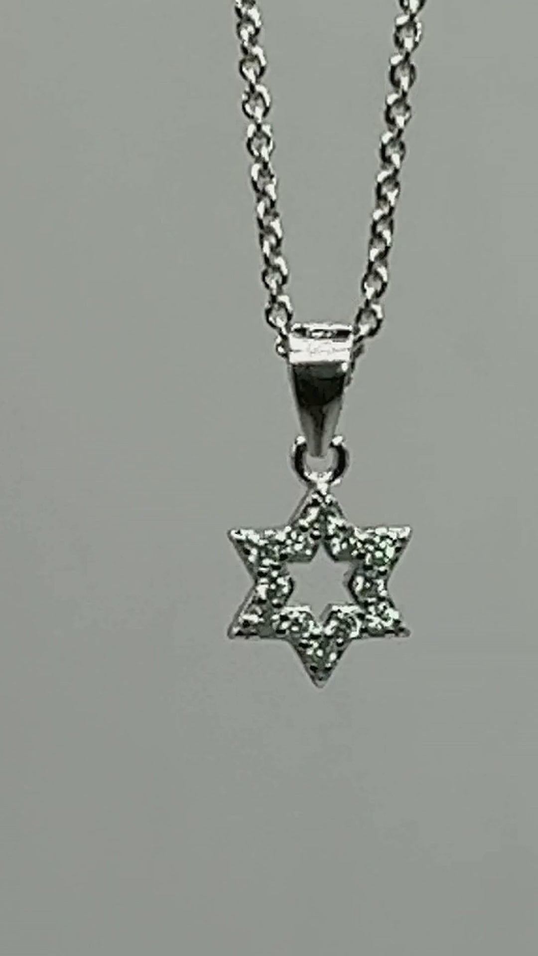 Dainty pavé Star of David pendant in 925 sterling silver turning on its chain